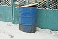 One old blue metal barrel stands in a drift of white snow Royalty Free Stock Photo