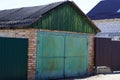 Old brick garage with green iron gate in the street Royalty Free Stock Photo