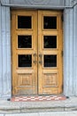 One old brown door made of wood and glass on a gray concrete wall Royalty Free Stock Photo