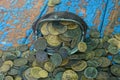 Brown leather wallet with a bunch of old coins on a blue rubbed wooden table Royalty Free Stock Photo