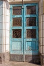 One old closed blue wooden door with gray glass on the concrete wall Royalty Free Stock Photo
