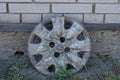 One old dirty plastic cap for a car wheel stands on the ground in green grass Royalty Free Stock Photo