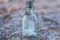 one old dirty small white gray glass bottle