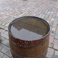 One old-fashioned wooden barrel on the pavement, after the rain