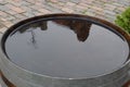 One old-fashioned wooden barrel on the pavement, after the rain