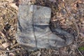 one old gray dirty leather boot lies on the ground Royalty Free Stock Photo