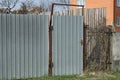 One old gray metal door and part of an iron fence Royalty Free Stock Photo