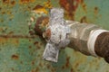 One old gray metal valve with a rusty bolt on an iron pipe Royalty Free Stock Photo