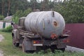 One old gray truck with a barrel