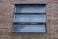 One old gray window on a brown brick wall of a building Royalty Free Stock Photo