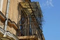 Old iron balcony overgrown with dry vegetation against the sky