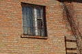 Old window with iron bars on a brown brick wall Royalty Free Stock Photo