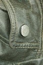 One old metallic gray rivet button on the black leather