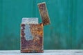 Old rusty shabby lighter stands on a gray table on a green background Royalty Free Stock Photo