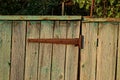 One old rusty metal brown door hinge on gray wooden fence Royalty Free Stock Photo