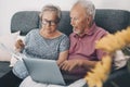 One old senior couple at home paying bills online with web banking app and checking the amounts on documents. Elderly and modern Royalty Free Stock Photo