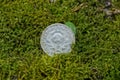 Old silver soviet coin with the coat of arms lies on the green moss