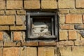 Old small walled window on the brick wall of the building