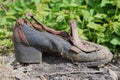 one old torn brown black dirty shoe stands on gray ground on the street Royalty Free Stock Photo
