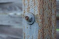 One old twisted nut on a bolt on a gray iron pillar Royalty Free Stock Photo