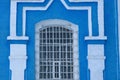 Old window behind iron bars on a brick blue white wall Royalty Free Stock Photo