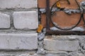 One old window behind an iron grate on a brick wall in red and grey Royalty Free Stock Photo