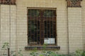 One old window behind an iron grate on a brown brick wall Royalty Free Stock Photo