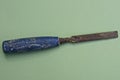One old working tool from a rusty iron chisel to a blue handle Royalty Free Stock Photo