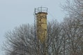 One old yellow iron water tower with a ladder covered in brown rust Royalty Free Stock Photo