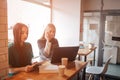 One-on-one meeting.Two young business women sitting at table in cafe. Girl shows colleague information on laptop screen Royalty Free Stock Photo