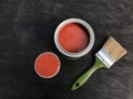 One open can with beautiful red paint on a black matte wooden background.