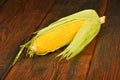 One open corn cob on vintage wooden surface Royalty Free Stock Photo