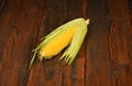 One open corn cob on vintage wooden surface Royalty Free Stock Photo