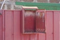 One open iron mailbox hanging on a red metal fence Royalty Free Stock Photo