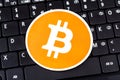 One orange bitcoin logo, circle symbol laying on black modern pc laptop netbook computer keyboard, crypto currency e-commerce Royalty Free Stock Photo