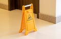 One orange caution slippery wet floor fold out sign in the hallway, workplace safety, accidents symbol, risk of falling, warning