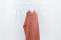 One orange pastel knit warm sweater on hanger and many empty hangers