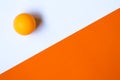 One orange ping pong ball on an orange and white background. Royalty Free Stock Photo