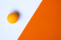 One orange ping pong ball on an orange and white background. Royalty Free Stock Photo