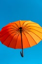 one orange umbrella flying in the wind