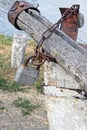 one padlock hanging from a brown rusty iron chain on a gray wooden log