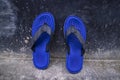 One Pair of Blue sandals flip flops beachwear on a dirty floor wall Royalty Free Stock Photo