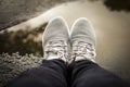 One pair gray tennis shoes with a water reflection background