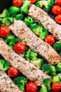 One pan dish baked salmon fillet with broccoli and tomato, vertical, top view, closeup Royalty Free Stock Photo