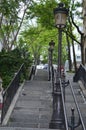 One part of the staircase on Montmartre with street lamps and large green trees