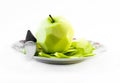 One peeled green apple with knife on a white plate and white background - front view Royalty Free Stock Photo