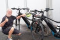 One people, senior man has finished washing the two bicycles and raises his thumb as a sign of victory