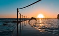 Silhouette of a man diving into a pool at sunrise