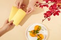One person is holding two lucky money envelopes for the other person, a plate of tangerines and orchid branches that stand out Royalty Free Stock Photo