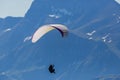 One person paragliding in the mountains